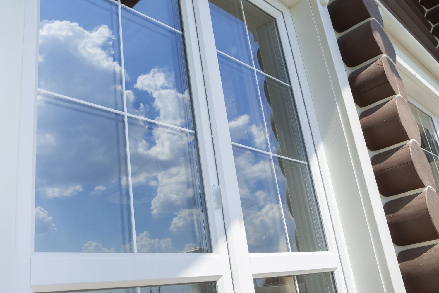 Une fenêtre et porte fenêtre PVC avec le reflet du ciel dans les vitres. 